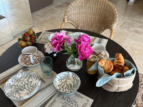 une table avec des assiettes, des bols et des fleurs dessus dans l'établissement Domaine des Eucalyptus, à Mollégès