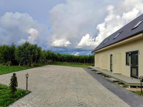 a house with a gravel driveway next to a building at Brzozowa Polana in Perlino