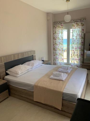a bedroom with a large bed with towels on it at Breeze - Cozy Beachfront Lux Apartment - Listen Piano & the waves in Flogita