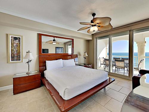 a bedroom with a bed and a view of the ocean at Beach Club #1202C in Pensacola Beach