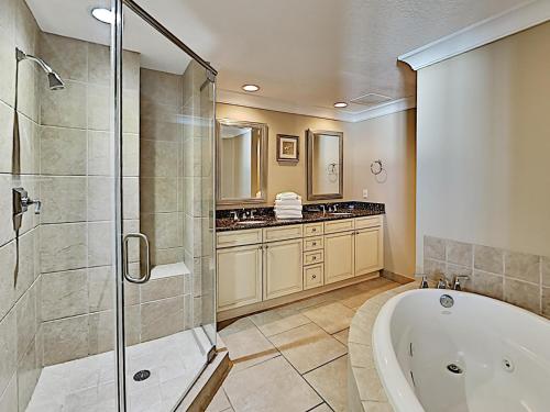 a bathroom with a tub and a glass shower at Beach Club #1202C in Pensacola Beach