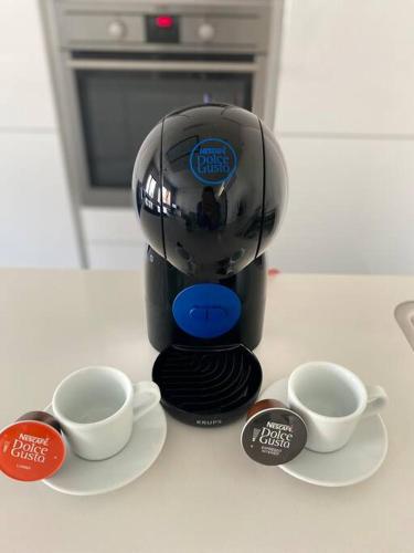 a coffee maker sitting on a table with two cups at Lovely One Bedroom Apartment in City Center with Parking, near Public Transport in Luxembourg
