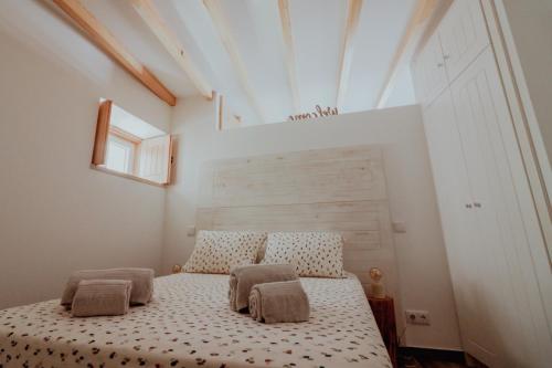 um quarto com uma cama com duas almofadas em Refúgio do Paixão em Sesimbra