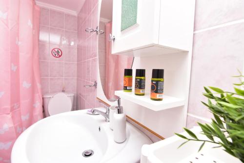 Un baño con lavabo, inodoro y espejo. en Iakovos apartments, en Chorafakia