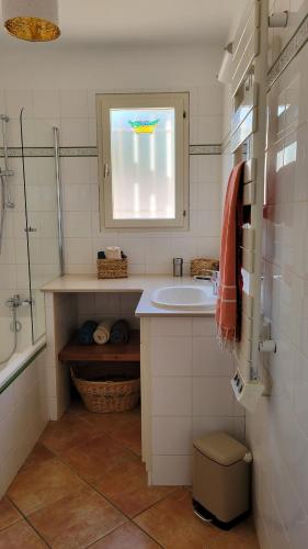 ein Bad mit einem Waschbecken und einem Fenster in der Unterkunft Villa en bord de mer face à l'Ile de Porquerolles in Hyères