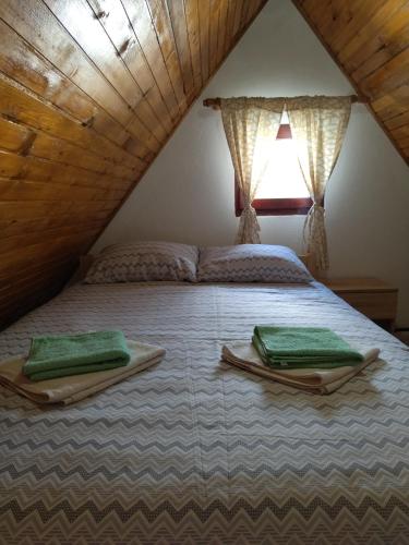 a bedroom with a bed with green towels on it at Apartments Snowflake in Žabljak