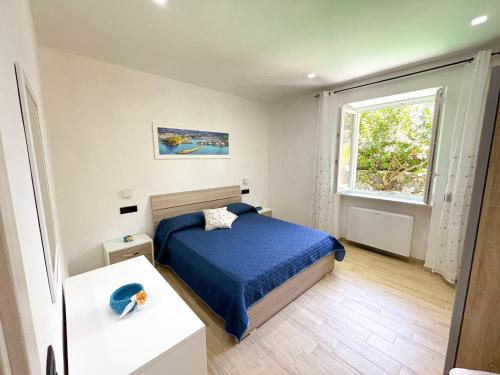 Habitación pequeña con cama y ventana en Maison Marinella, en Isquia