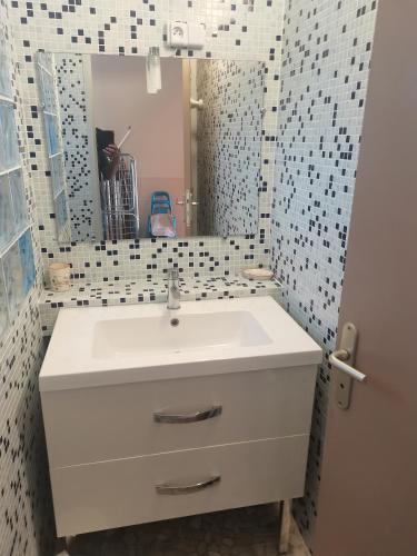 a bathroom with a white sink and a mirror at Les Gites de Kevinou in Vallon-Pont-dʼArc
