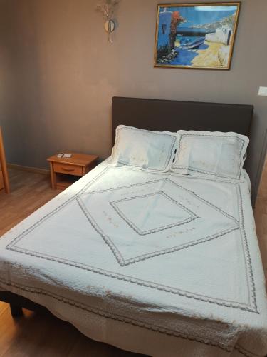 a bed with a white bedspread and pillows on it at Les Gites de Kevinou in Vallon-Pont-dʼArc