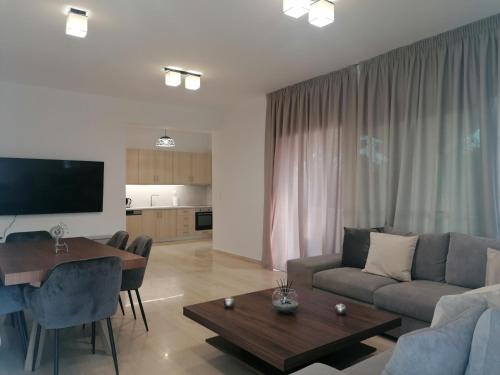 uma sala de estar com um sofá e uma mesa em Casa para ti Villa em Porto Heli