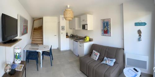 a living room with a couch and a table at Résidence l’Esprit de la mer in Combrit