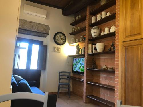 uma sala de estar com uma televisão e uma parede de tijolos em La Casina di Tonia em Terracina