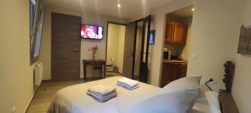 une chambre avec un lit blanc avec deux serviettes dessus dans l'établissement Le Rouveau, à Six-Fours-les-Plages