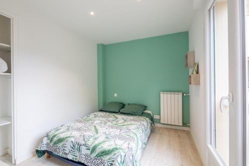 une chambre avec un lit avec un mur bleu dans l'établissement Meublé 2 étoiles, WIFI, à 2 pas des plages, à Fréjus