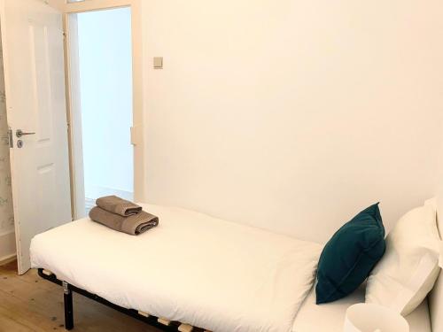 a white bed with a bag sitting on top of it at Portuguese apartment in the heart of Lisbon in Lisbon