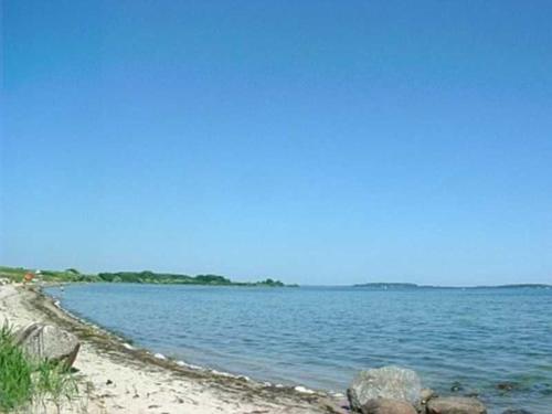 a large body of water with rocks on the shore at Ruegen_Fewo 63 in Garz-Rügen