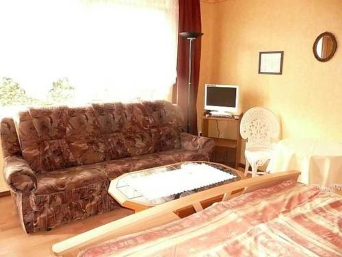 a living room with a couch and a desk with a computer at Ruegen_Fewo 63 in Garz-Rügen