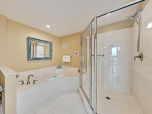 a bathroom with a tub and a glass shower stall at The Pearl of Navarre #1403 in Navarre