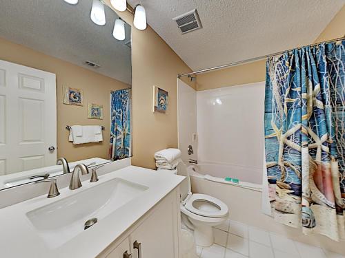 a bathroom with a white sink and a toilet at The Pearl of Navarre #1403 in Navarre