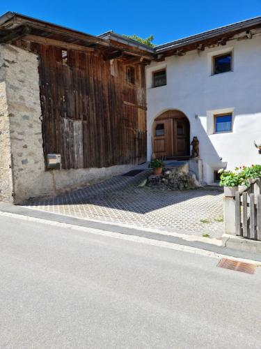 a house with a wooden door on the side of a street at Lumpaz in Sta Maria Val Müstair