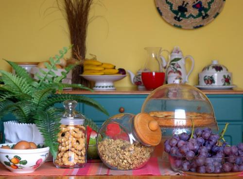 einen Tisch mit einem Haufen Obst und einer Schale Nüsse in der Unterkunft BB DoliaHouse in Dolianova