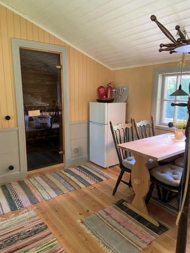 a kitchen with a table and chairs and a refrigerator at Linhagen Gård in Säffle