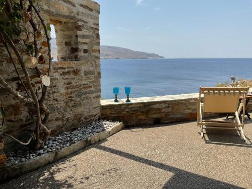 two blue glasses sitting on a ledge next to the ocean at KeaSouth in Koundouros