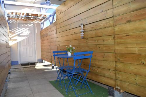 a blue stool in front of a wooden wall at Appartement La JOIE dans quartier chic in Pibrac