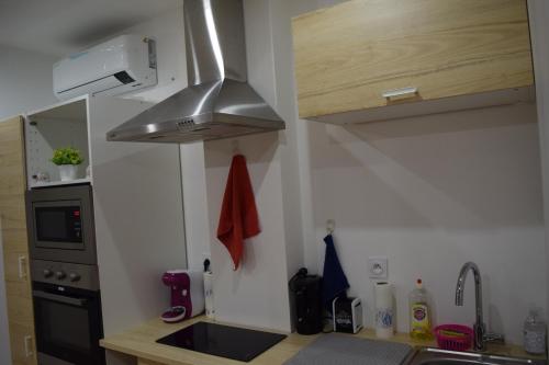 a small kitchen with a sink and a stove at Appartement La JOIE dans quartier chic in Pibrac