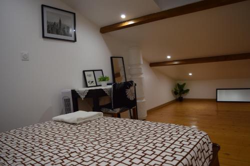 a bedroom with a bed and a desk in a room at Appartement La JOIE dans quartier chic in Pibrac