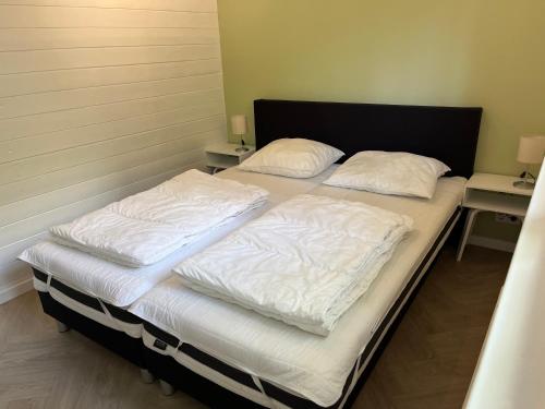 two beds in a room with white sheets and pillows at Villa Frederik with sauna in Winterswijk in Winterswijk