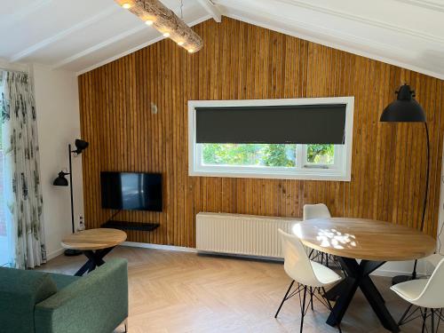 a living room with a table and a television at Villa Frederik with sauna in Winterswijk in Winterswijk