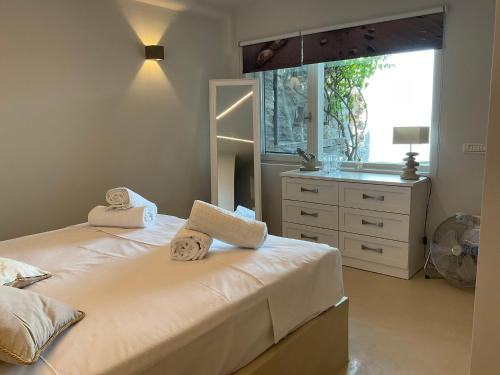 a bedroom with two beds and a window and a dresser at KeaSouth in Koundouros