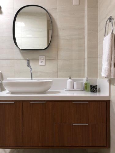 a bathroom with a sink and a mirror at QUARTO INTEIRO com banheiro exclusivo Coração de Florianópolis in Florianópolis