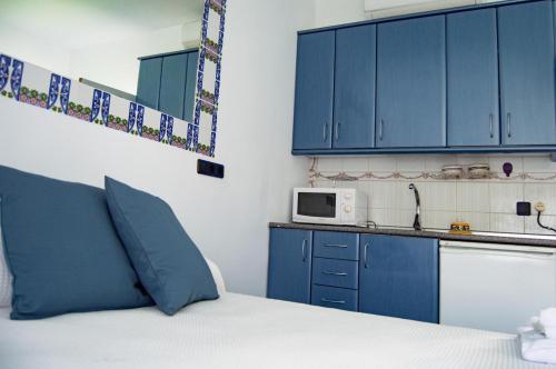 uma cozinha com uma cama com armários azuis e um micro-ondas em Zahara Beach EL REFUGIO em Zahara de los Atunes