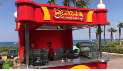 a man standing in front of a fast food truck at شاليه فاخر بالبانوراما بورتوسخنه للعائلات فقط porto sokhna chalets in Ain Sokhna
