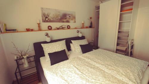 a bedroom with a bed with white sheets and pillows at An der Bremke in Herzberg am Harz