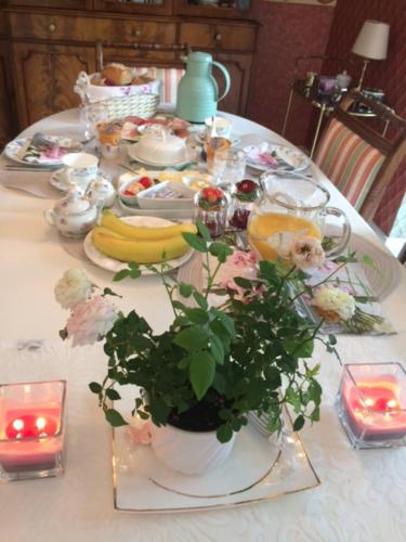 a table with a bunch of food and flowers on it at Pension Roseneck in Wolfshagen