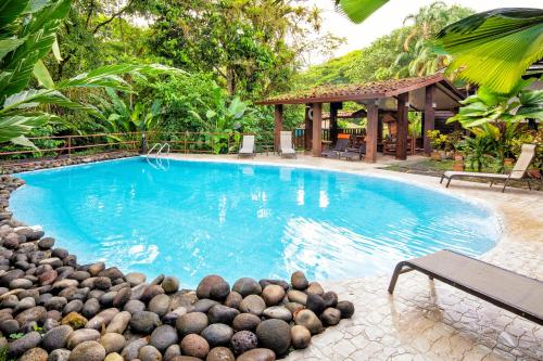 una piscina con un montón de rocas alrededor en La Quinta Sarapiqui Lodge, en Sarapiquí
