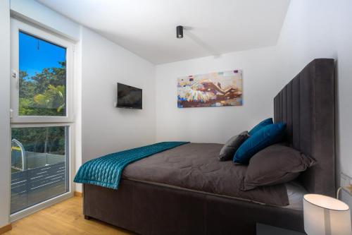 een slaapkamer met een groot bed en een raam bij Apartment Larissa in Njivice