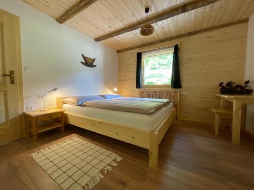 1 dormitorio con 1 cama en una habitación con ventana en Apartma Korošec en Srednja Vas v Bohinju