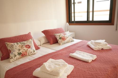 a bedroom with towels on a bed with a window at VIVIR EL MORRAZO in Cangas de Morrazo