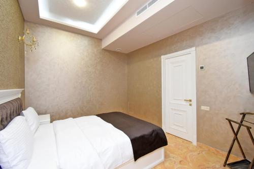 a bedroom with a white bed and a skylight at Macao Hotel in Yerevan