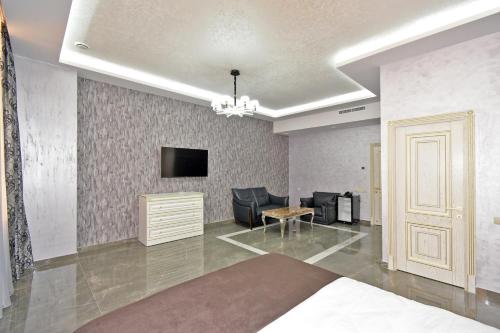 a bedroom with a bed and a tv on a wall at Macao Hotel in Yerevan