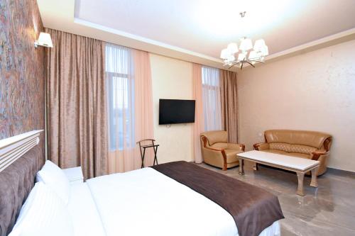 a hotel room with a bed and a tv at Macao Hotel in Yerevan