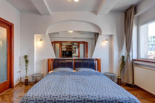 a bedroom with a bed with a blue comforter at Old Town Home Library in Bucharest