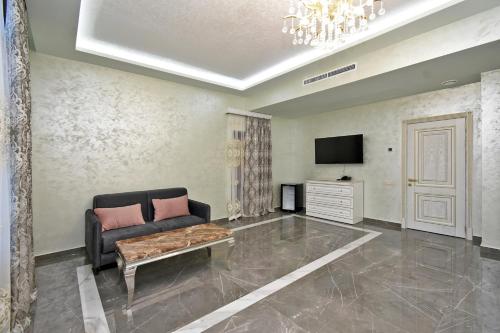 a living room with a couch and a tv at Macao Hotel in Yerevan