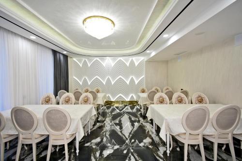 a conference room with white tables and chairs at Macao Hotel in Yerevan