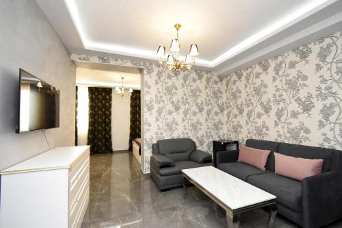 a living room with a couch and a tv at Macao Hotel in Yerevan