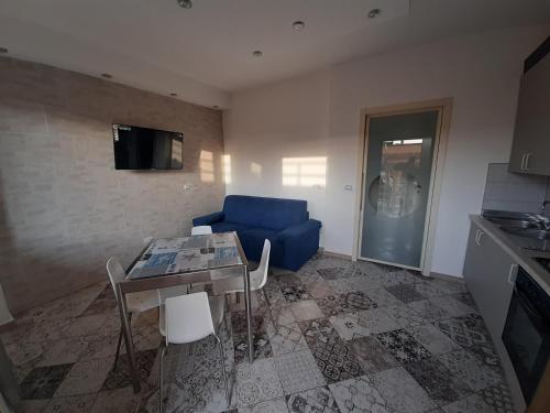 Terra di mare apartment & management في زامبروني: غرفة معيشة مع أريكة زرقاء وطاولة